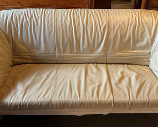 Lot 26: Beige leather sofa and love seat with blue and patterned throw pillows