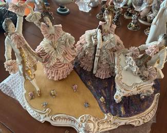 This breathtaking mid-20th century Dresden Lace Porcelain Figural Grouping showcases an elite level of ceramic mastery native to Germany's historic Thuringia region. Hand-painted in an opulent Rococo salon motif (circa 1950s), the massive estate piece features four courtly musicians adorned in impeccably preserved, impossibly delicate ruffles of fossilized porcelain lace