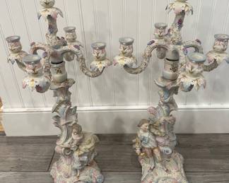 This magnificent pair of authentic, mid-20th century German Porcelain Figural Candelabras showcases masterfully hand-painted Rococo-style court figures in traditional 18th-century attire. Encrusted with incredibly delicate, three-dimensional applied floral blossoms, each unmarked 5-light estate centerpiece represents the finest decorative craftsmanship native to Germany's historic Thuringia region