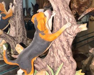 Dog chase raccoon up tree figurine 