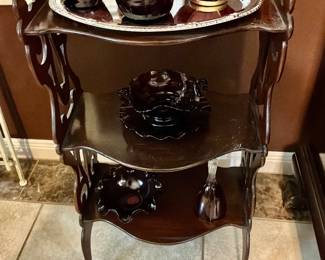 Style mahogany three tiered side table with intricate carved decorative element