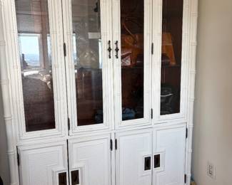 Fabulous faux bamboo china cabinet with metal detailing used as bedroom clothing storage.