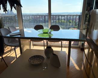 CB2 lacquered dining table in creamy white pristine with glass top.