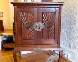 This is a vintage Herzog music cabinet from the early 1900s featuring claw feet and a marble top.