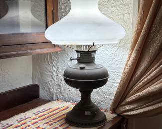 Vintage table lamp features a brass base and an opaque white glass shade