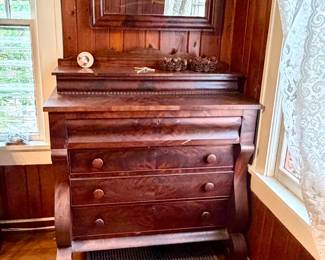 19th-century American Empire dresser features distinctive flame mahogany and sweeping curved sides