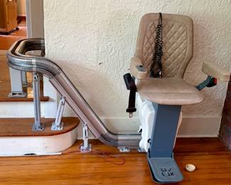 UP Stairlift has a  Modular Design: Features a unique, low-profile modular rail system that can be adjusted on-site to fit any staircase configuration. Premium Comfort: Equipped with a luxury quilted faux-leather seat in a sand/beige finish. Automated Options: Includes a power swivel seat and an automatic folding footrest for safer entry and exit. Smart Connectivity: Features built-in Wi-Fi and remote diagnostics.