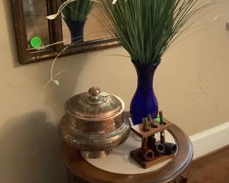 Round table with marble like top. Copper like mirror hanging above.