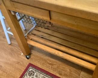 Butcher block cart in kitchen. It has a basket, pull out tray, thrash tray, and is in rollers. Price: $145.00