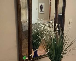 Copper like mirror above cabinet.