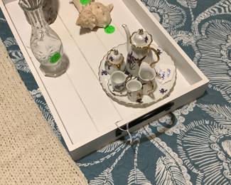 White tray on bed with child’s tea service.