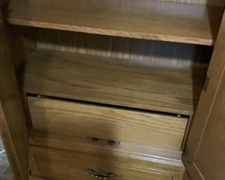 Oak chest in master bedroom with shelves and drawers. Long drawer at top.