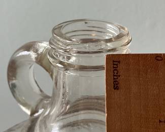 M19 - $20. Garrett's 1 Gallon American Wine. The glass is a faint peach color. Measures 6.75" wide x 5.25" x 11.5" tall.