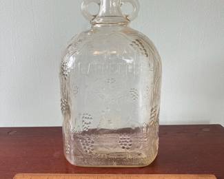 M19 - $20. Garrett's 1 Gallon American Wine. The glass is a faint peach color. Measures 6.75" wide x 5.25" x 11.5" tall.