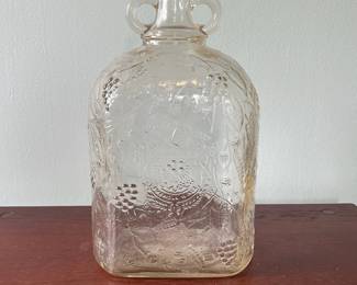 M19 - $20. Garrett's 1 Gallon American Wine. The glass is a faint peach color. Measures 6.75" wide x 5.25" x 11.5" tall.