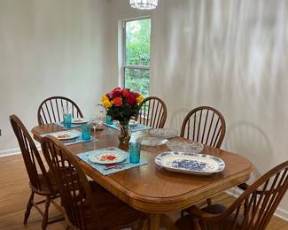 Solid oak, double pedestal dining table and chairs with 2 extension leaves; Windsor Chairs with 2 Captain’s Arm Chairs; dishes and glassware