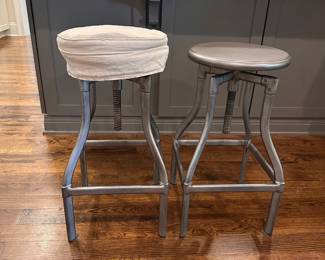 F44 - $175 PAIR. Crate & Barrel Turner Gunmetal Adjustable Backless Counter Stools. Seats are 13" round. Adjusts from 24-30" tall. Includes seat covers for both.