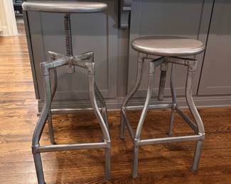 F44 - $175 PAIR. Crate & Barrel Turner Gunmetal Adjustable Backless Counter Stools. Seats are 13" round. Adjusts from 24-30" tall. Includes seat covers for both.