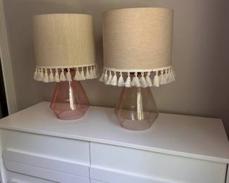 F56 - $25 Each. Pink Lamps - 2 available. Same style but slightly different colors. Measures 22.5" tall. Shades are both in good condition. Lamp bases are glass and are open on the bottom.