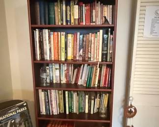 Dark Wood Bookshelf with Assorted Books and Decorative Items