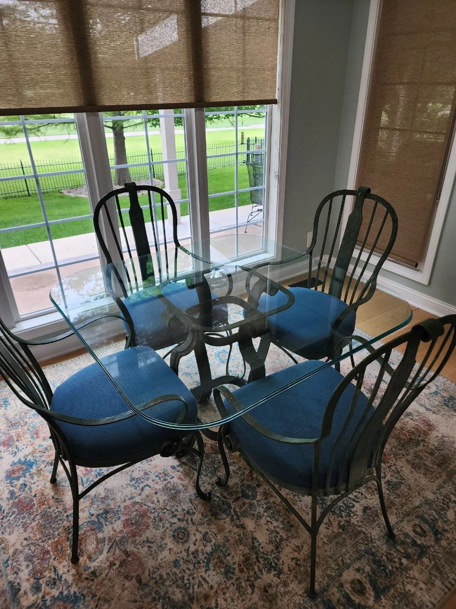 Glass top table with 4 Wright iron blue cushioned chairs