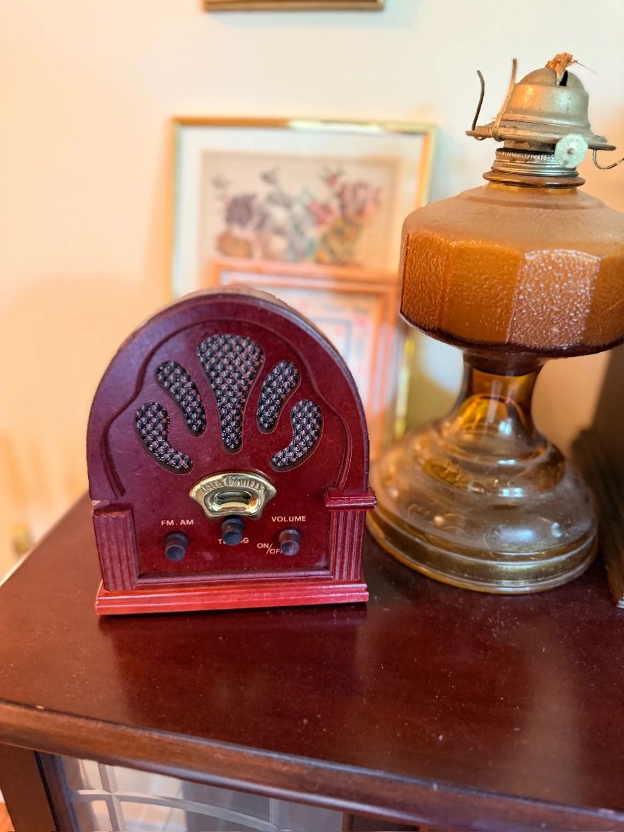 Vintage cathedral-style radio and antique amber glass oil lamp
