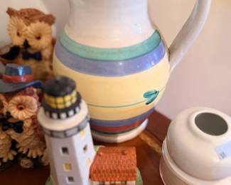Striped ceramic pitcher and lighthouse figurine
