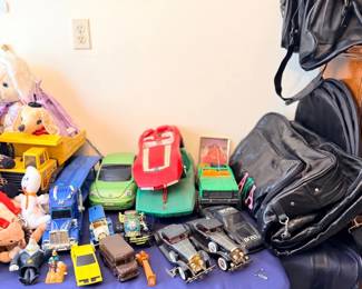 Toy cars, trucks and luggage