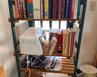 Shelf with cookbooks, kitchen utensils and pottery