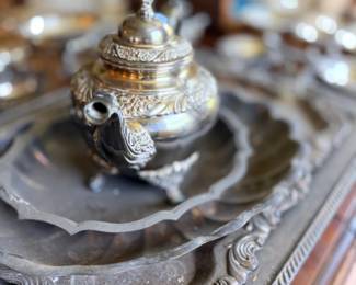 Ornate silver covered dish with finial on tray