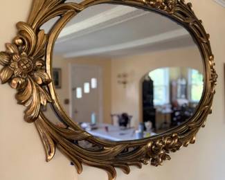 Ornate oval gold gilt-framed wall mirror