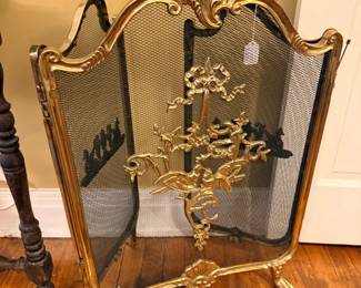 Ornate brass fireplace screen with scrollwork