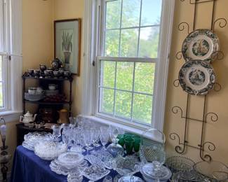 Table of cut crystal and glassware with wall plate rack