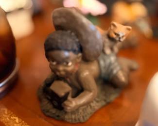 Figurine of child reading with cat