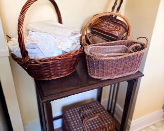 Assorted wicker baskets and linens on side table