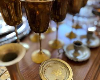 Brass goblets, candlesticks and coasters