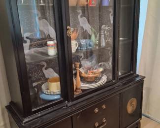 Black lacquered Century China Cabinet features gold hardware and a distinct crane-themed interior wallpaper