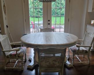 Vintage style white distressed round pedestal dining table with a rustic aesthetic