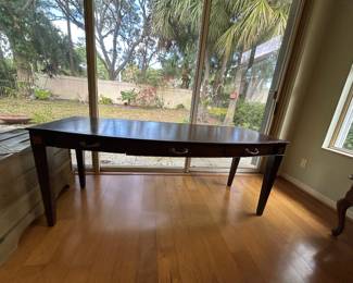 Wooden table or desk. Contains 3 shallow drawers for storage