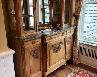 $590. Beautiful marble and carved wood buffet or bar. Interior lighting. Three drawers with cabinets below. 63 inches wide by 22 inches deep by 78 inches high.  Filled with sterling for sale during in-person shopping.