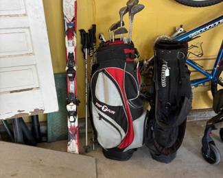 Golf bags with a few clubs and kid's skis