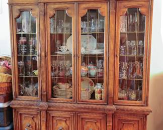 Drexel Heritage Francesca China Cabinet Vintage Drexel Heritage Francesca China Cabinet Stunning vintage Drexel Heritage Francesca Collection china cabinet featuring a rich walnut finish, elegant arched crown, glass display doors, and the collection's signature brass ring-pull hardware. A beautiful statement piece offering both display and concealed storage. The upper cabinet features glass-front display doors with adjustable shelving, perfect for showcasing fine china, crystal, stemware, collectibles, or decorative pieces. The lower cabinet provides additional enclosed storage and includes a dedicated fine silver storage drawer. Designed in two separate sections, allowing for easier transport and moving.