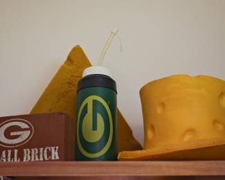 Original Green Bay Packers Cheesehead Collection No Packers collection would be complete without the iconic Cheesehead® hats that have become synonymous with Green Bay football fandom. This fun grouping features original foam Cheesehead hats along with additional Packers fan collectibles. Featured Items Include: Original vintage foam Cheesehead hats Green Bay Packers "Bad Call Brick" novelty collectible Packers logo sports water bottle Additional Green Bay Packers fan memorabilia These classic Cheeseheads are a must-have for Packers fans and make great additions to a fan cave, sports room, tailgate collection, or memorabilia display.