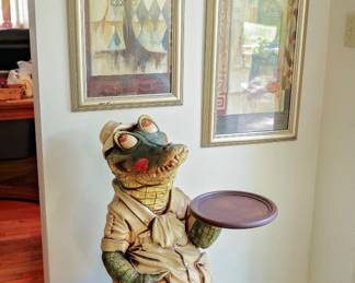 Tropical Alligator Butler Statue Whimsical Tropical Alligator Butler Serving Stand Fun and eye-catching decorative alligator butler statue featuring a tropical resort-inspired design. This charming gator is dressed in island attire and holds a serving tray, making it perfect as a conversation piece, drink stand, snack server, or decorative accent for a Florida room, patio, bar area, game room, or lake house. Beautifully detailed with hand-painted finishes and a sturdy tray ideal for holding beverages, appetizers, keys, or decorative items. Features: Tropical alligator butler design Hand-painted decorative finish Integrated serving tray Freestanding floor sculpture Perfect for coastal, Florida, tropical, tiki, or lake house décor Fun conversation piece. 