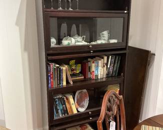 Vintage Mahogany 5-Tier Barrister Bookcase Description: A classic, traditional-style stackable barrister bookcase crafted in a rich mahogany finish. This multi-functional piece features a crown molding top and a total of five spacious tiers designed for showcasing literary collections, fine glassware, or decorative curios. Two of the central tiers feature signature glass-front lift-and-recede doors with small brass knobs, offering dust-free protection, while the remaining tiers provide open-shelf styling for easy access. Ideal for a sophisticated study, office, or dining area display. Estimated Dimensions: Width: 36" Depth: 12" Height: 72"