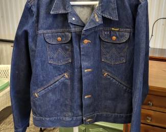 Collection grade Wrangler 74126 PW (pre-washed) "No Fault"  denim trucker jacket, made in the USA between 1974 &1976. It has been worn very little. It is made of 100% Sanfor-Set dark indigo heavy-duty 14 ounce broken twill denim. It has Western (Wrangler) stitching on the chest pockets, a pencil slot on the pocket, a black neck tag, brass buttons and slanted welt pockets at the waist.
