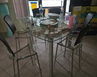These are leftover from last week's sale We found the seats we're bringing two chairs with us so you can see what they look like. But the set is located at last week's estate sale. It is a rounded triangle glass top bistro height table and six chairs for $250. Do not come here looking for it. it's located indialantic