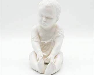 Bisque Porcelain Figure of a Seated Child Holding Foot