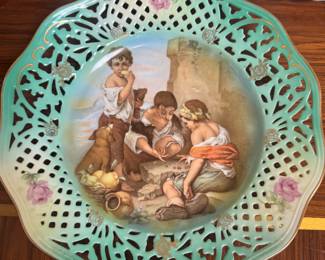 This vintage Schumann Arzberg porcelain plate from Germany features a pierced, reticulated edge and a transfer design of children playing.