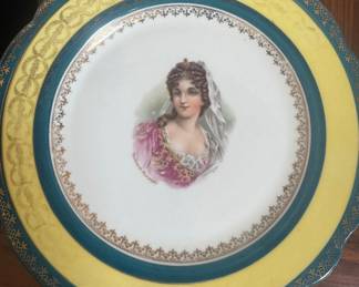 Austria This image shows an antique Royal Vienna style porcelain portrait plate featuring a hand-painted depiction of a woman with a yellow border and gold gilding